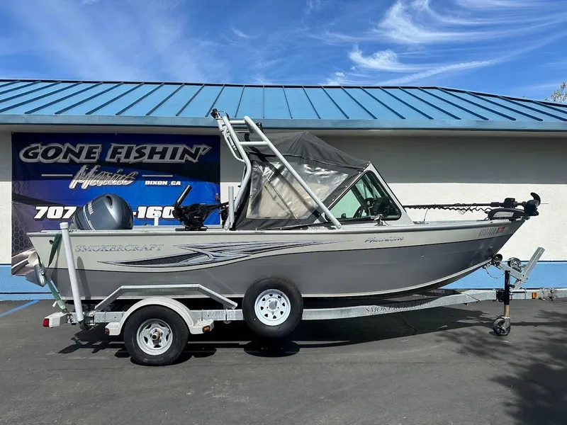 Slide: The Image of 2017 Smoker Craft 182 Phantom boat on trailer, parked outside a fishing store. - 1