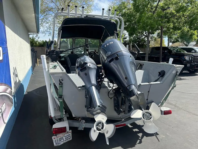 Slide: The Image of 2017 Smoker Craft 182 Phantom boat with dual outboard motors, parked outdoors. - 12