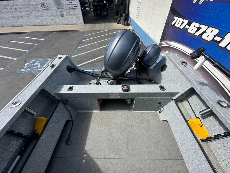 Slide: The Image of 2017 Smoker Craft 182 Phantom boat with dual outboard motors in a parking lot. - 13