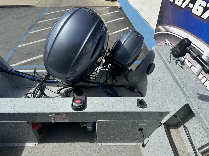 Slide: The Image of 2017 Smoker Craft 182 Phantom boat with dual outboard motors in a parking lot. - 18