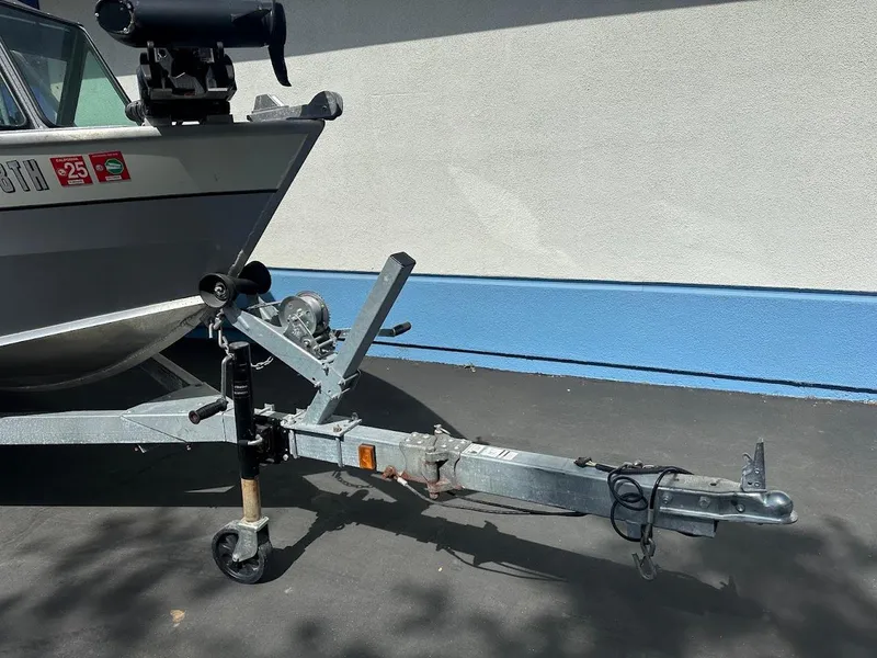 Slide: The Image of 2017 Smoker Craft 182 Phantom boat on trailer, parked on asphalt near blue wall. - 5