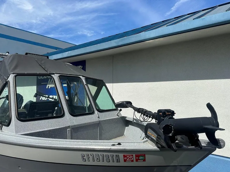 Slide: The Image of 2017 Smoker Craft 182 Phantom boat with canopy, docked near a building under a blue sky. - 7