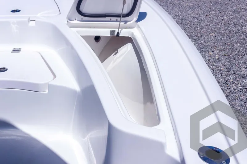 Slide: The Image of 2025 Tidewater 2410 Bay Max boat storage compartment, open lid, white interior, gravel background. - 24