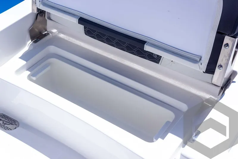 Slide: The Image of 2025 Tidewater 2410 Bay Max boat storage compartment, open lid, white interior, stainless steel hinges. - 42