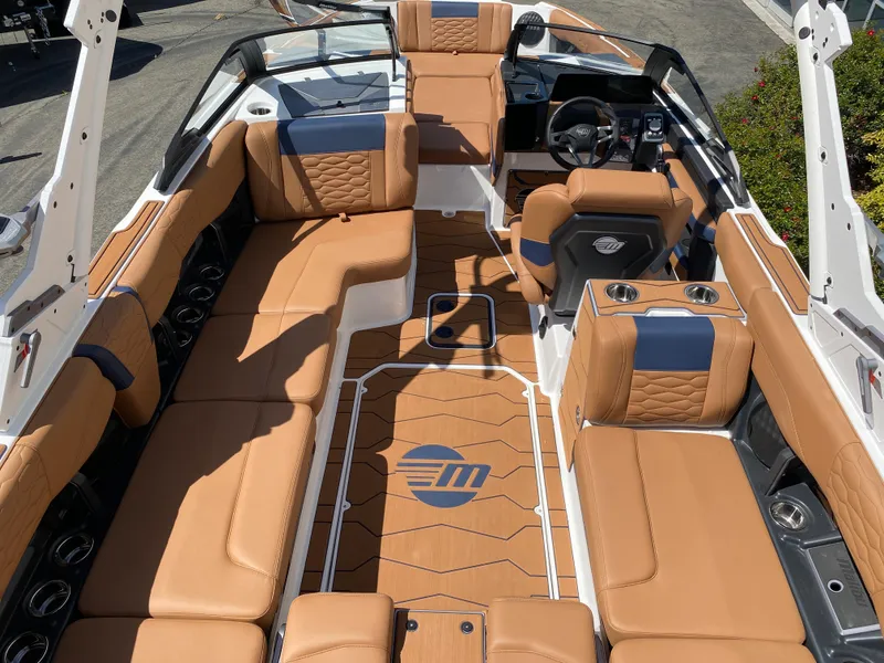 Slide: The Image of 2025 Malibu Wakesetter 24 MXZ boat interior with tan and blue seating, sleek design. - 10