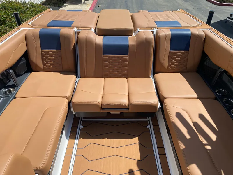 Slide: The Image of Luxurious interior of 2025 Malibu Wakesetter 24 MXZ with tan and blue seating. - 11