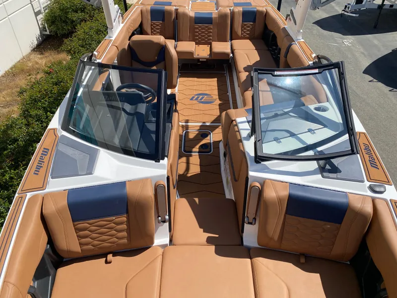 Slide: The Image of 2025 Malibu Wakesetter 24 MXZ boat with luxurious tan and blue seating. - 20