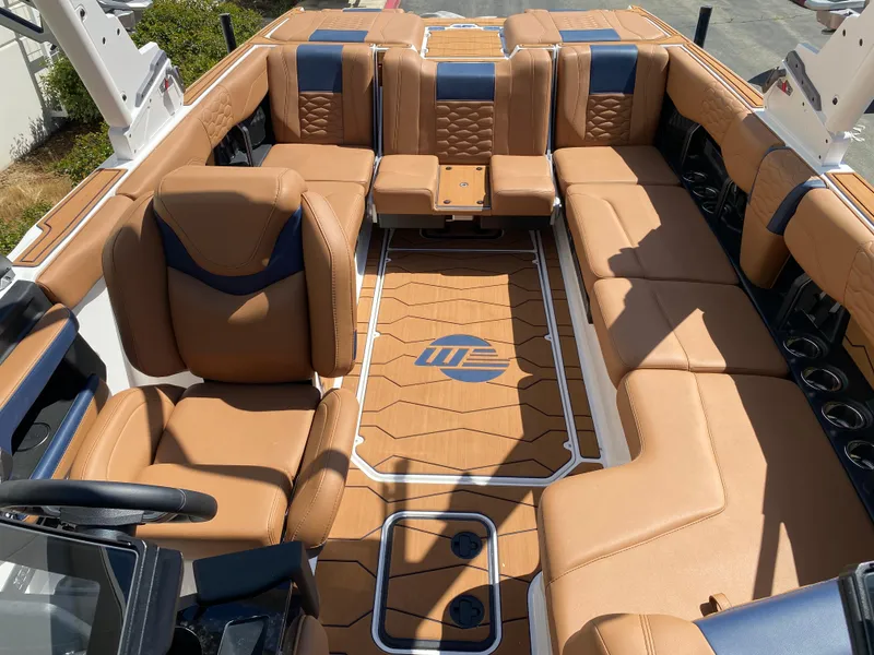 Slide: The Image of 2025 Malibu Wakesetter 24 MXZ interior with luxurious tan and blue seating. - 9