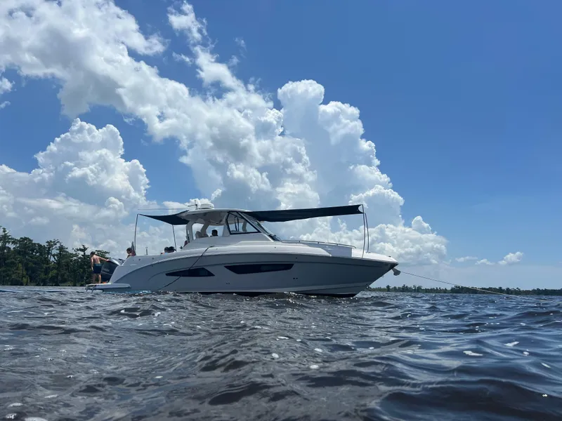 Slide: The Image of 2019 Regal 33 SAV boat on water under blue sky with clouds. - 0