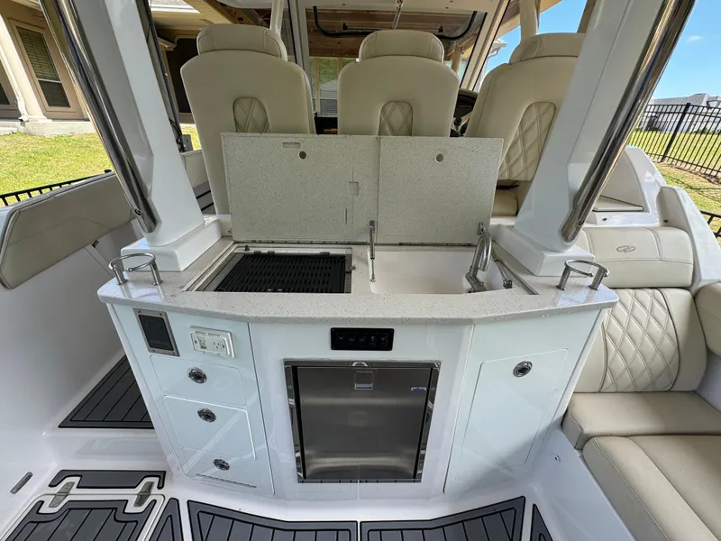 Slide: The Image of 2019 Regal 33 SAV boat interior with kitchenette and seating area. - 15