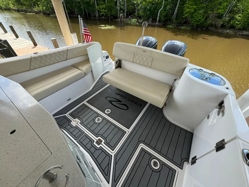 Slide: The Image of 2019 Regal 33 SAV boat interior with seating and deck, docked by a river. - 19