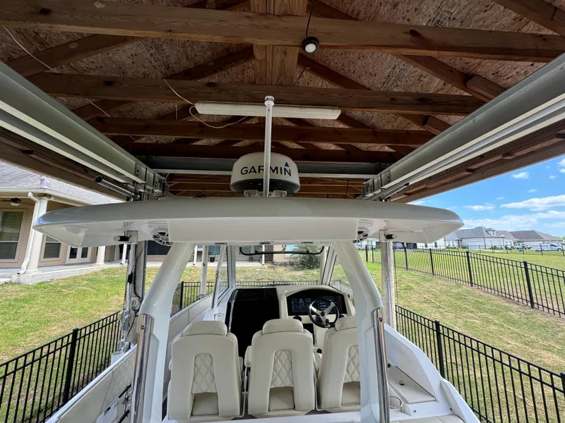Slide: The Image of 2019 Regal 33 SAV boat under wooden shelter with Garmin equipment. - 20