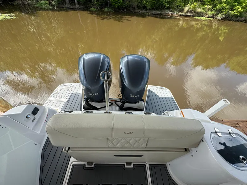 Slide: The Image of 2019 Regal 33 SAV boat with twin outboard engines on a calm river. - 22