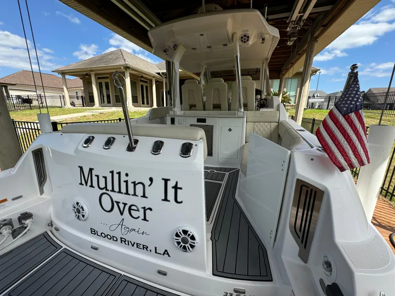 Slide: The Image of 2019 Regal 33 SAV boat docked, featuring "Mullin' It Over" name and American flag. - 24