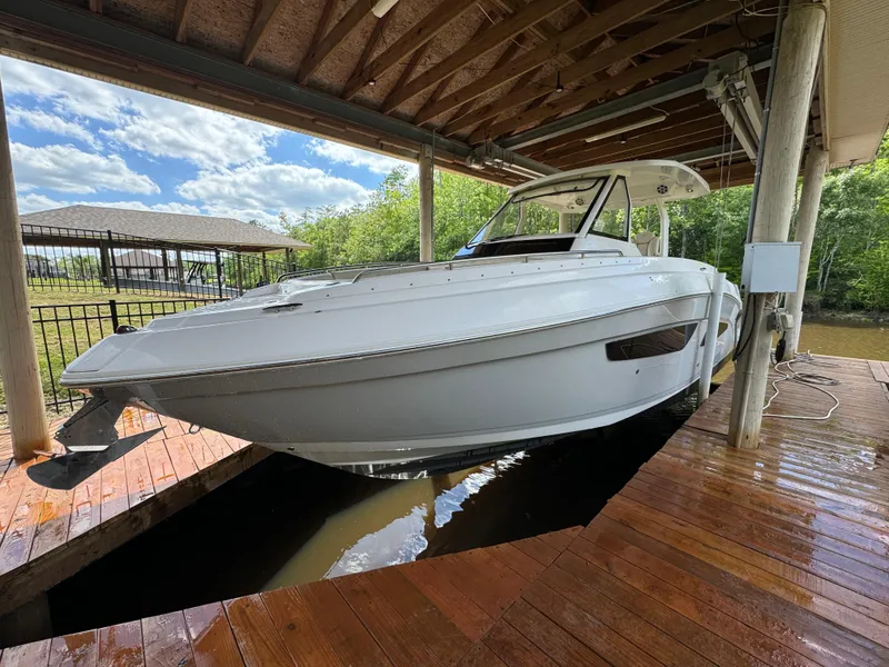 Slide: The Image of 2019 Regal 33 SAV boat docked under wooden shelter on a sunny day. - 3
