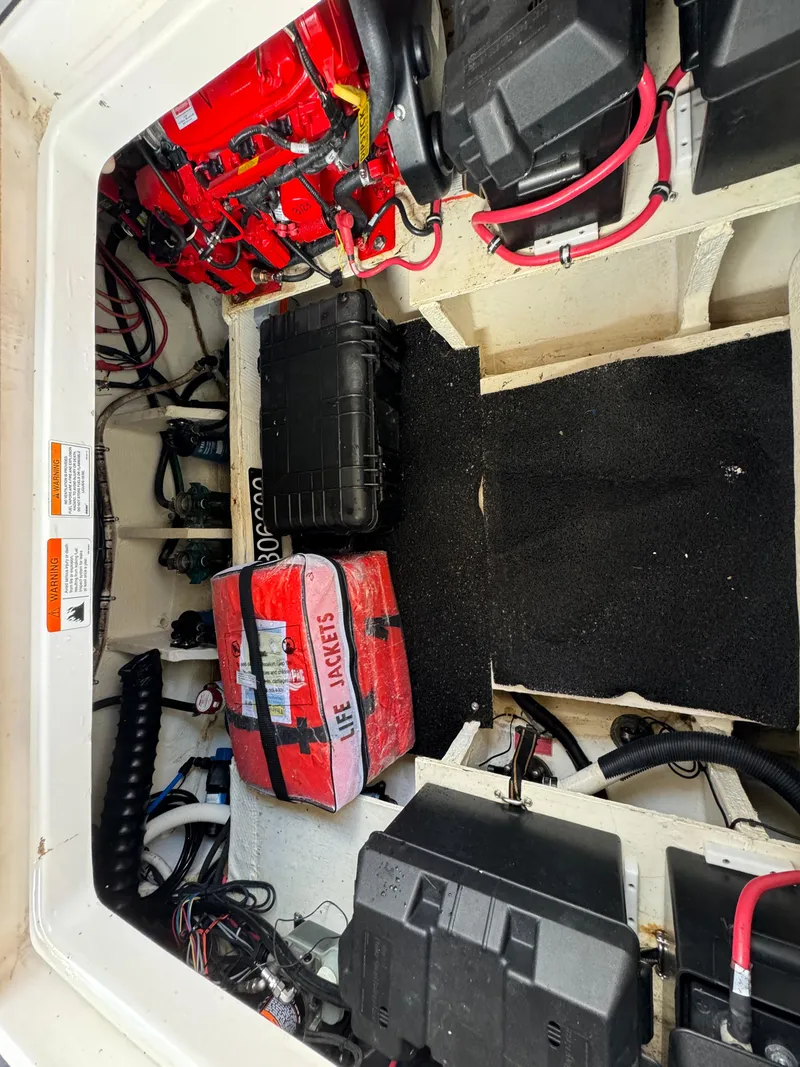 Slide: The Image of 2019 Regal 33 SAV boat storage compartment with life jackets and battery setup. - 36