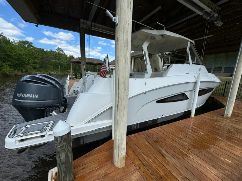 Slide: The Image of 2019 Regal 33 SAV boat docked with Yamaha outboard motor, under a covered pier. - 5