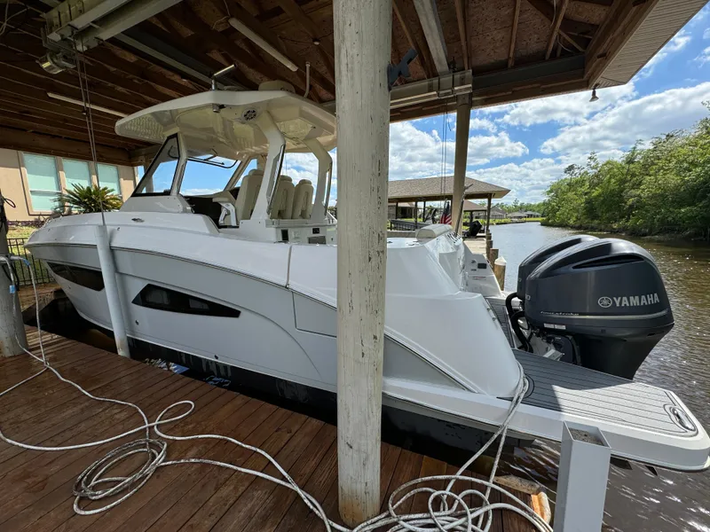 Slide: The Image of 2019 Regal 33 SAV boat docked with Yamaha engine, under a wooden canopy. - 6