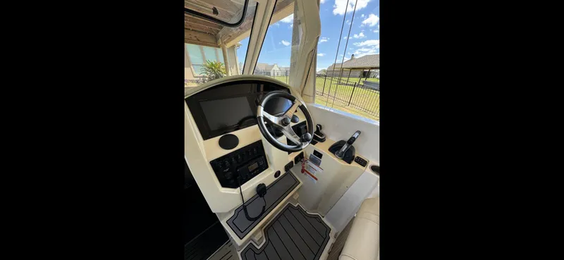 Slide: The Image of 2019 Regal 33 SAV boat helm with steering wheel and control panel. - 9