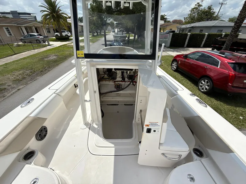 Slide: The Image of 2021 Robalo 246 Cayman SD boat interior with open storage compartment, parked on a residential street. - 21