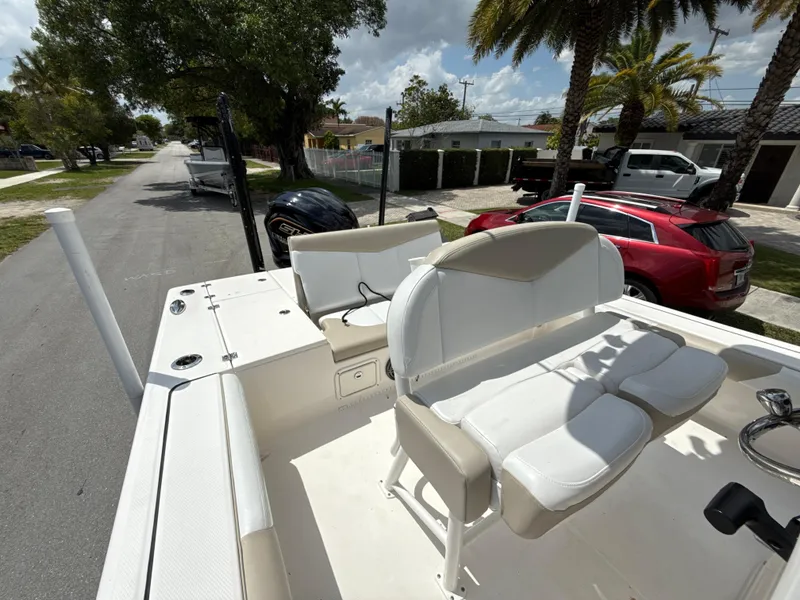 Slide: The Image of 2021 Robalo 246 Cayman SD boat with seating, parked on a sunny street. - 23