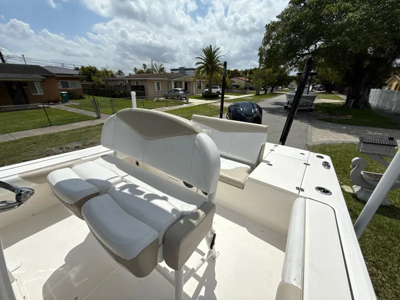 Slide: The Image of 2021 Robalo 246 Cayman SD boat with white seating, parked in a suburban neighborhood. - 24