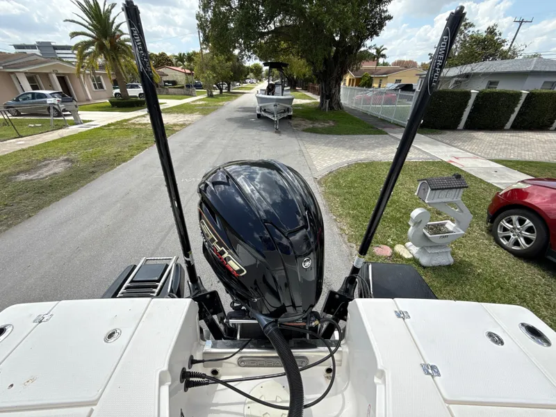 Slide: The Image of 2021 Robalo 246 Cayman SD boat with powerful outboard motor on a residential street. - 5