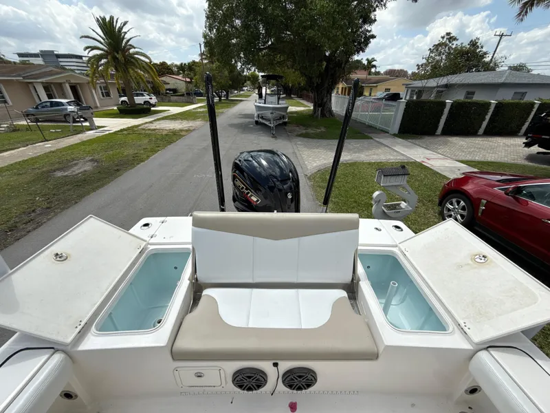 Slide: The Image of 2021 Robalo 246 Cayman SD boat with open storage compartments, parked on a residential street. - 7