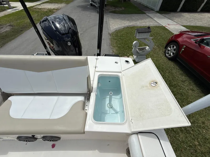 Slide: The Image of 2021 Robalo 246 Cayman SD boat with open storage compartment and seating area. - 8
