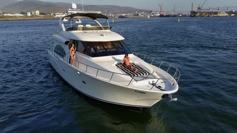 Slide: The Image of 2004 Meridian 580 Pilothouse yacht cruising in a scenic harbor setting. - 2