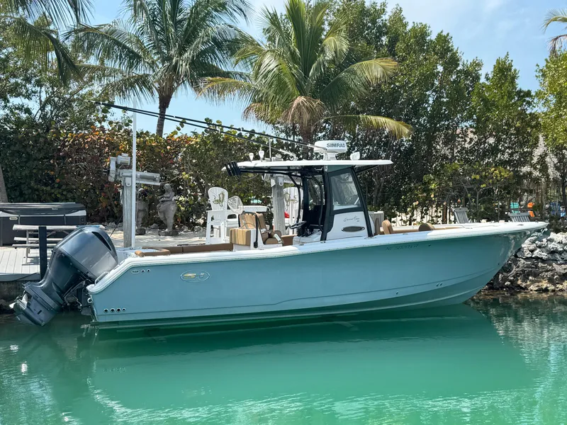 Slide: The Image of 2020 Sea Hunt Gamefish 30 boat docked in tropical setting with palm trees. - 12