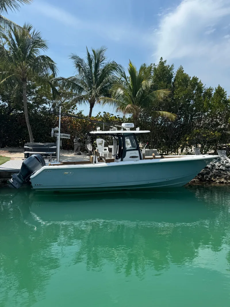 Slide: The Image of 2020 Sea Hunt Gamefish 30 boat docked in tropical waters with palm trees. - 14