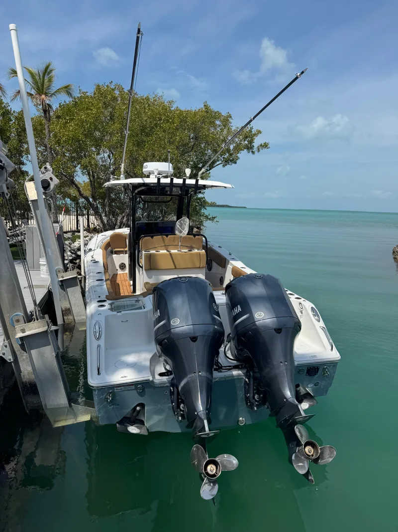 Slide: The Image of 2020 Sea Hunt Gamefish 30 boat with dual engines docked by turquoise water. - 15