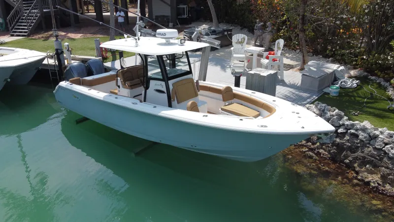 Slide: The Image of 2020 Sea Hunt Gamefish 30 boat with forward seating docked in clear water. - 2