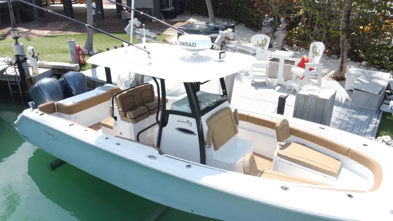 Slide: The Image of 2020 Sea Hunt Gamefish 30 boat with forward seating, docked near a waterfront. - 6