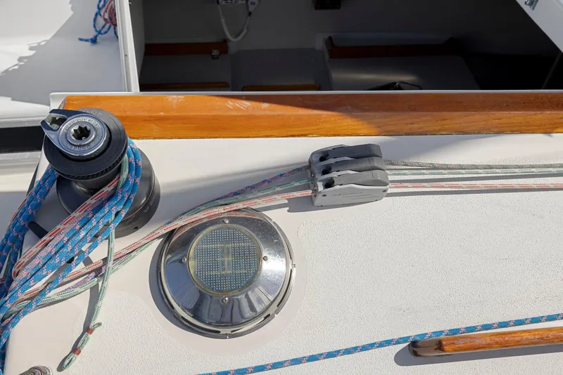 Slide: The Image of 2004 Wyliecat 30 sailboat deck with winch, ropes, and solar vent. - 12