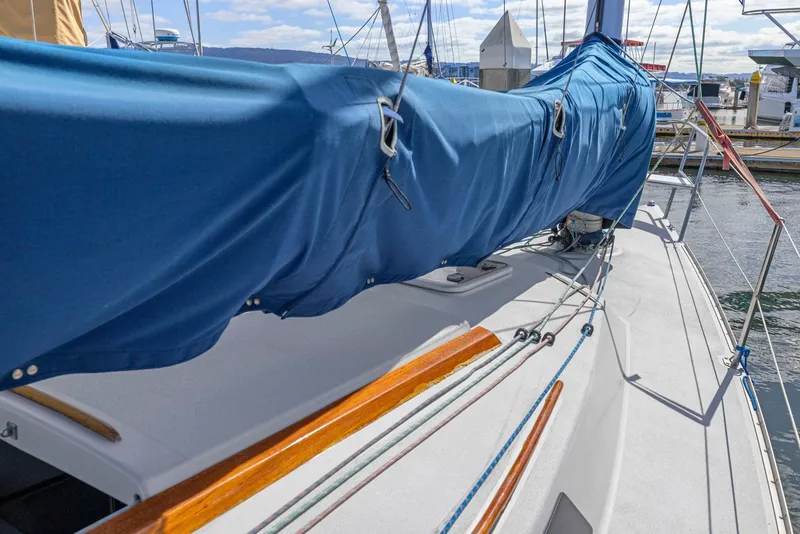 Slide: The Image of 2004 Wyliecat 30 sailboat with blue sail cover docked at marina. - 13