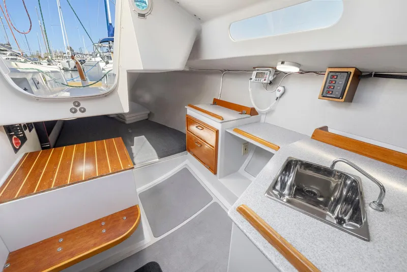 Slide: The Image of Interior of 2004 Wyliecat 30 sailboat with kitchenette and wooden accents. - 20