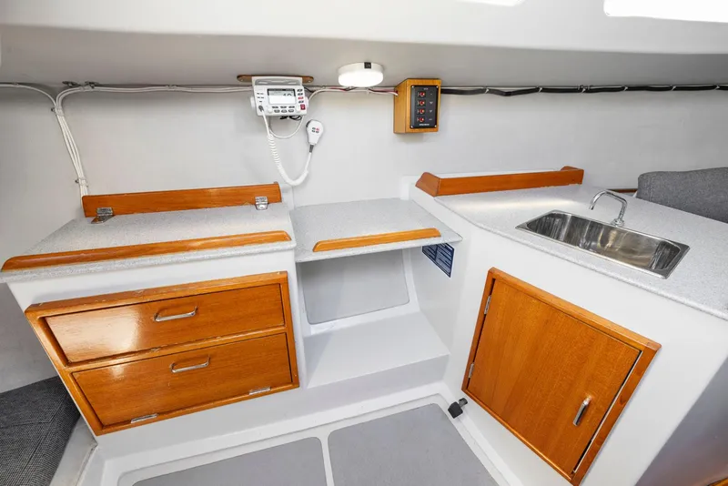 Slide: The Image of Interior of 2004 Wyliecat 30 sailboat with wooden cabinets and stainless steel sink. - 22