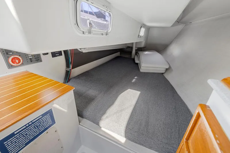 Slide: The Image of Interior cabin of 2004 Wyliecat 30 sailboat, featuring carpeted flooring and compact design. - 23