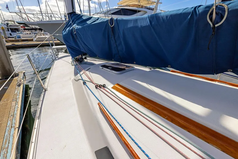 Slide: The Image of Sailboat deck view of 2004 Wyliecat 30 with blue cover in marina. - 5