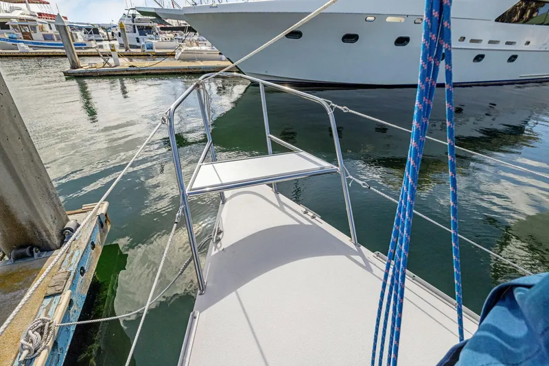 Slide: The Image of 2004 Wyliecat 30 sailboat docked in marina, featuring sleek deck and railing. - 6