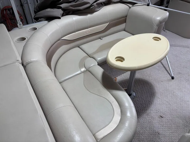 Slide: The Image of 2011 Avalon LS 23' RE boat interior with beige seating and oval table. - 10