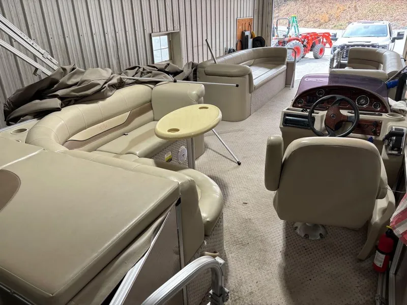 Slide: The Image of 2011 Avalon LS 23' RE pontoon boat interior with beige seating and steering console. - 15