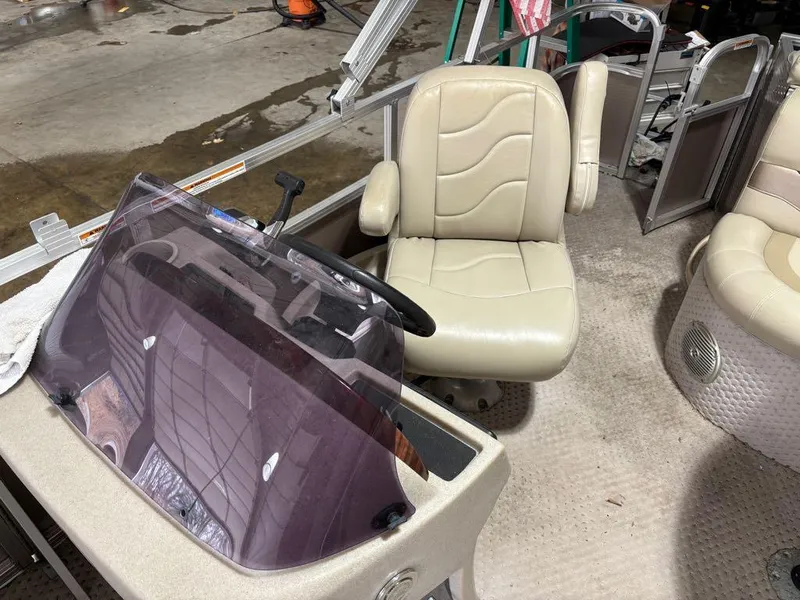 Slide: The Image of Interior of a 2011 Avalon LS 23' RE boat with beige seating and steering console. - 17