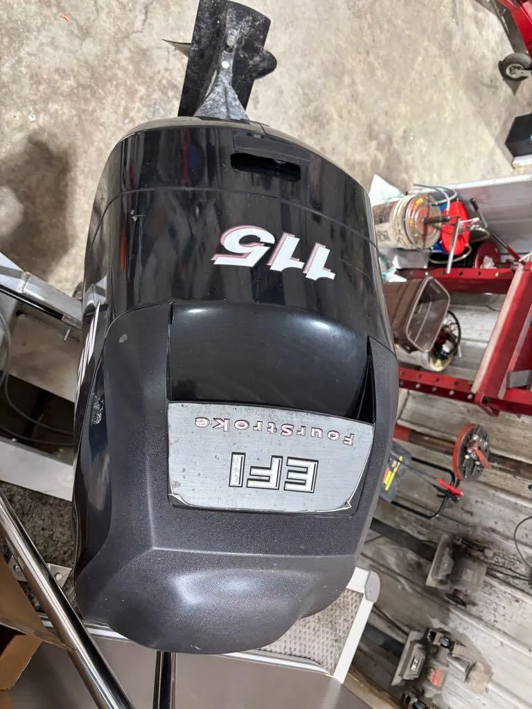 Slide: The Image of EFI 115 four-stroke outboard motor in a workshop setting. - 18