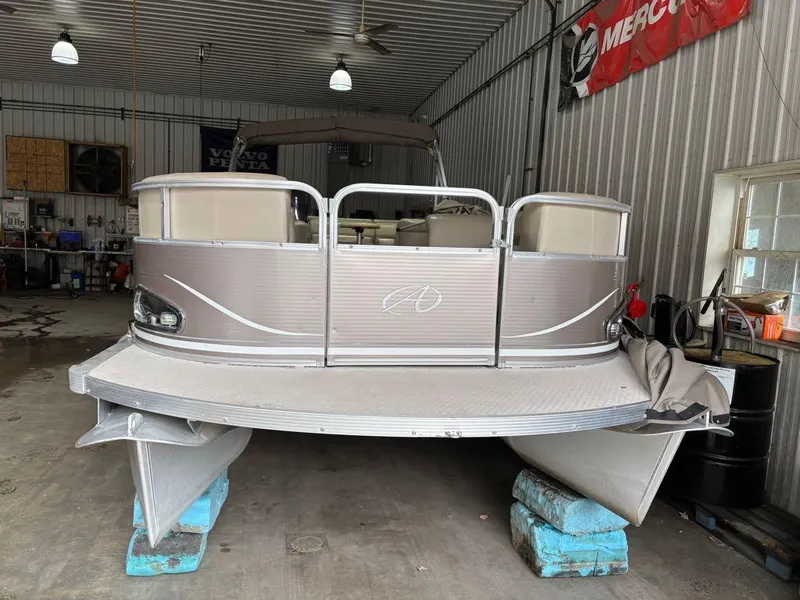Slide: The Image of 2011 Avalon LS 23' RE pontoon boat in a garage, elevated on blocks. - 3