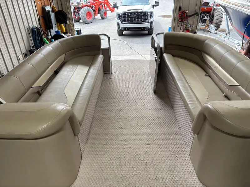 Slide: The Image of Interior of 2011 Avalon LS 23' RE pontoon boat with beige seating in a garage. - 5