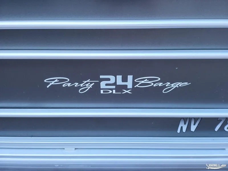 Slide: The Image of 2020 Tracker Party Barge 24 DLX logo on boat exterior. - 11