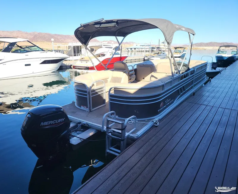 Slide: The Image of 2020 Tracker Party Barge 24 DLX pontoon boat docked with Mercury outboard motor. - 5